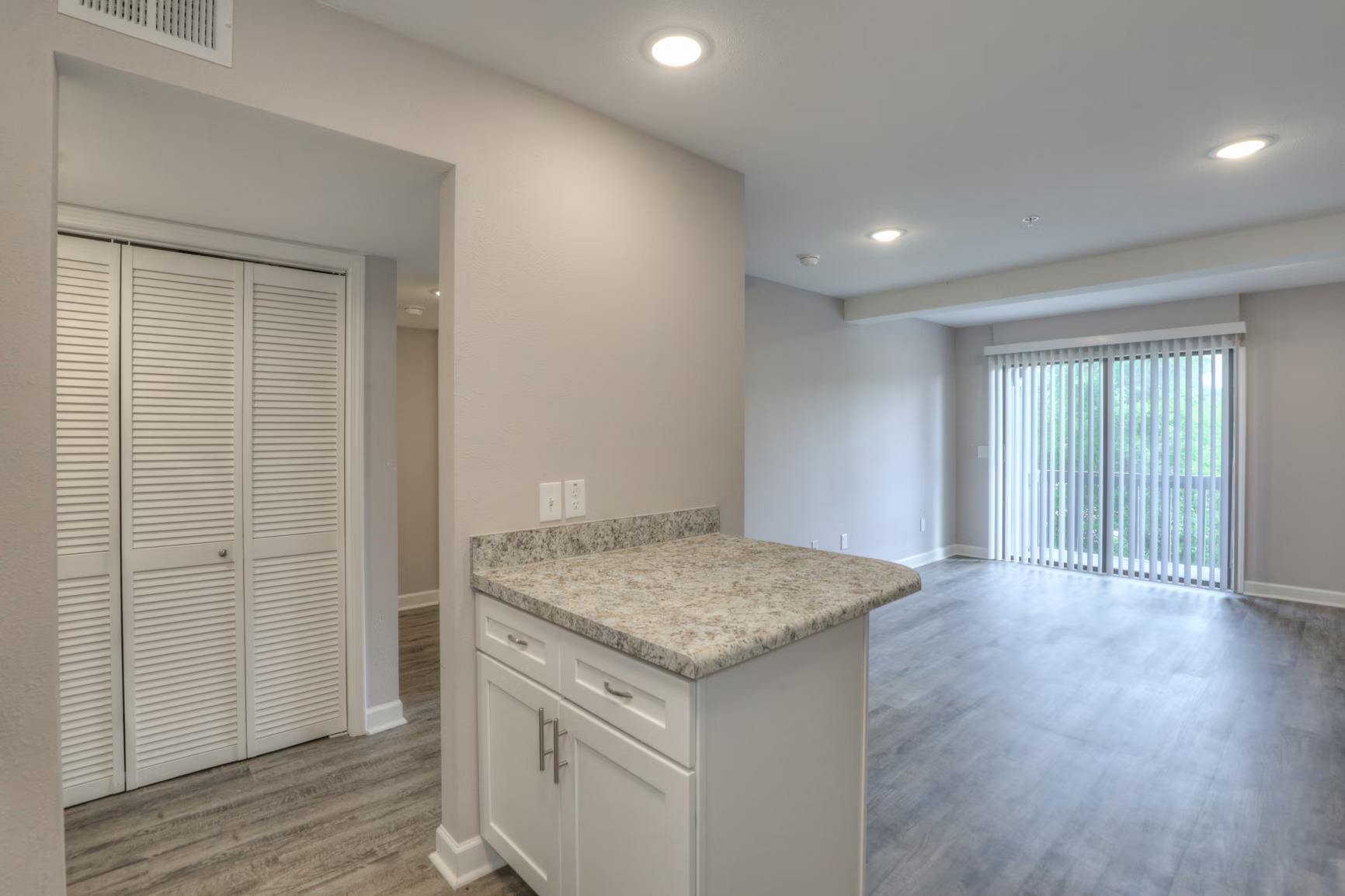A kitchen with white cabinets and a granite countertop.